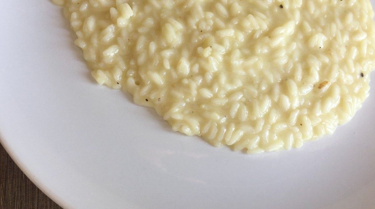 Creamy risotto alla parmigiana on a white plate, close up
