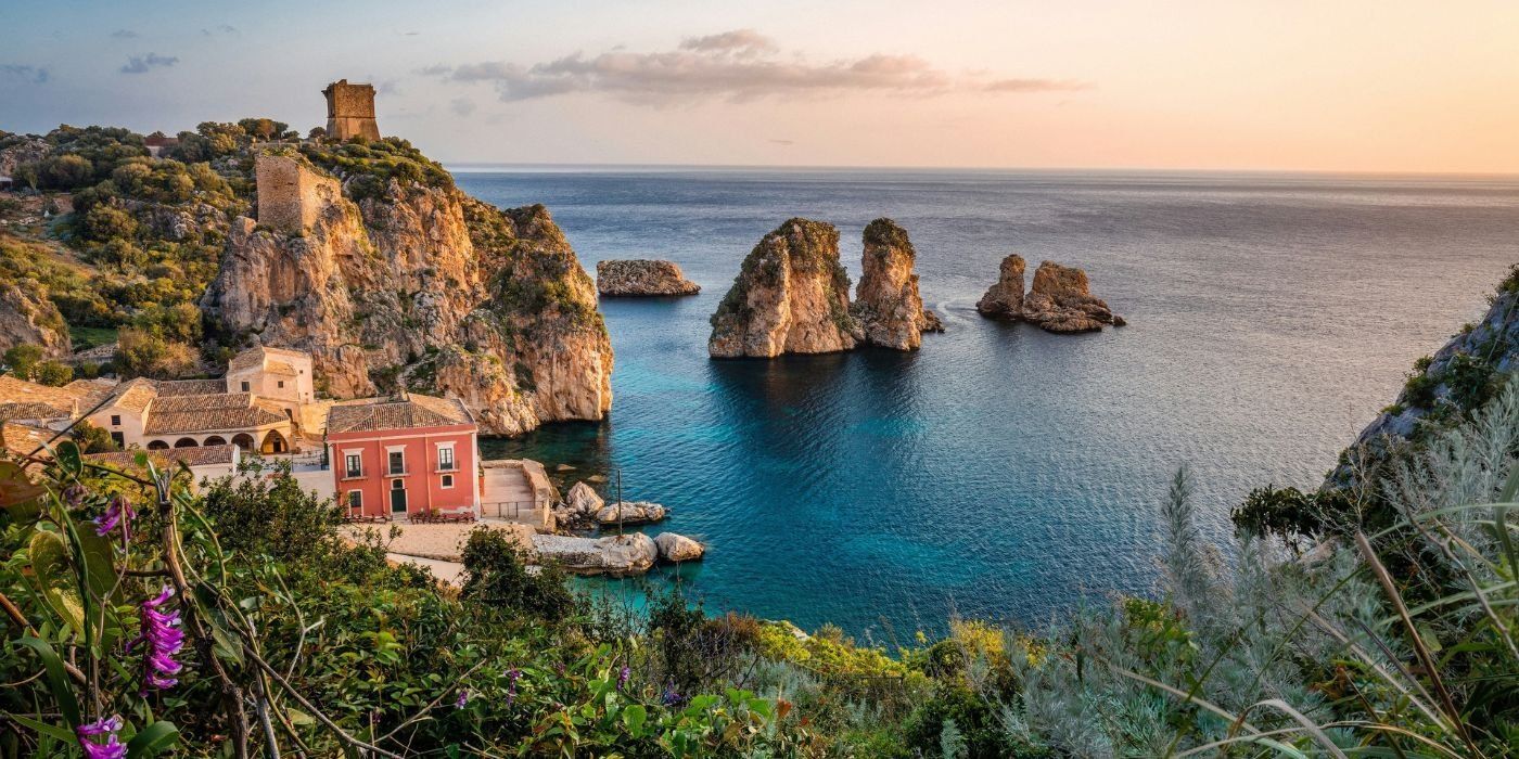 Los farallones y la antigua almadraba de Scopello, en la costa noroeste de Sicilia, bajo un cielo rosa pálido