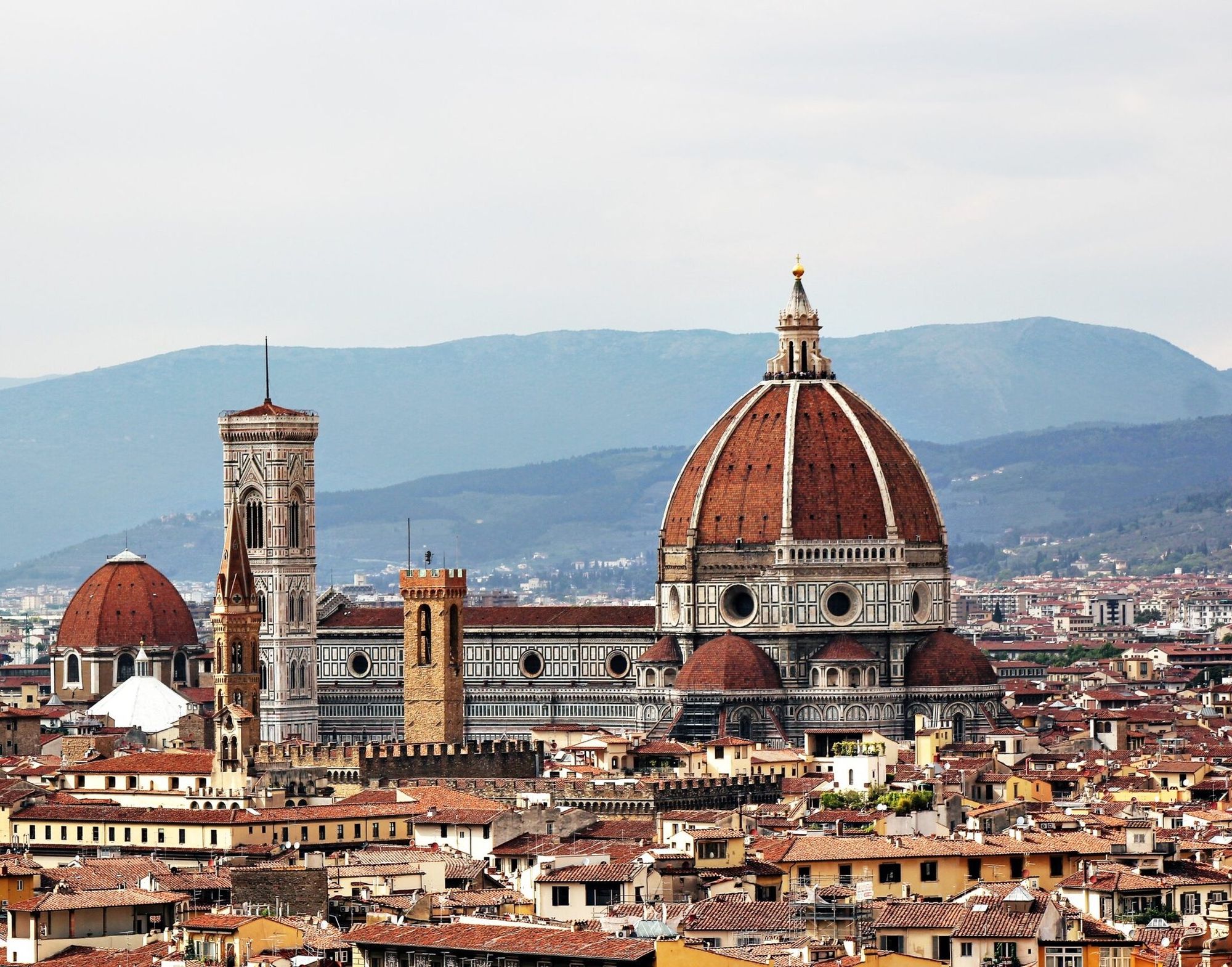 La cúpula de Brunelleschi y el campanario de Giotto sobre los tejados de Florencia, con las colinas al fondo