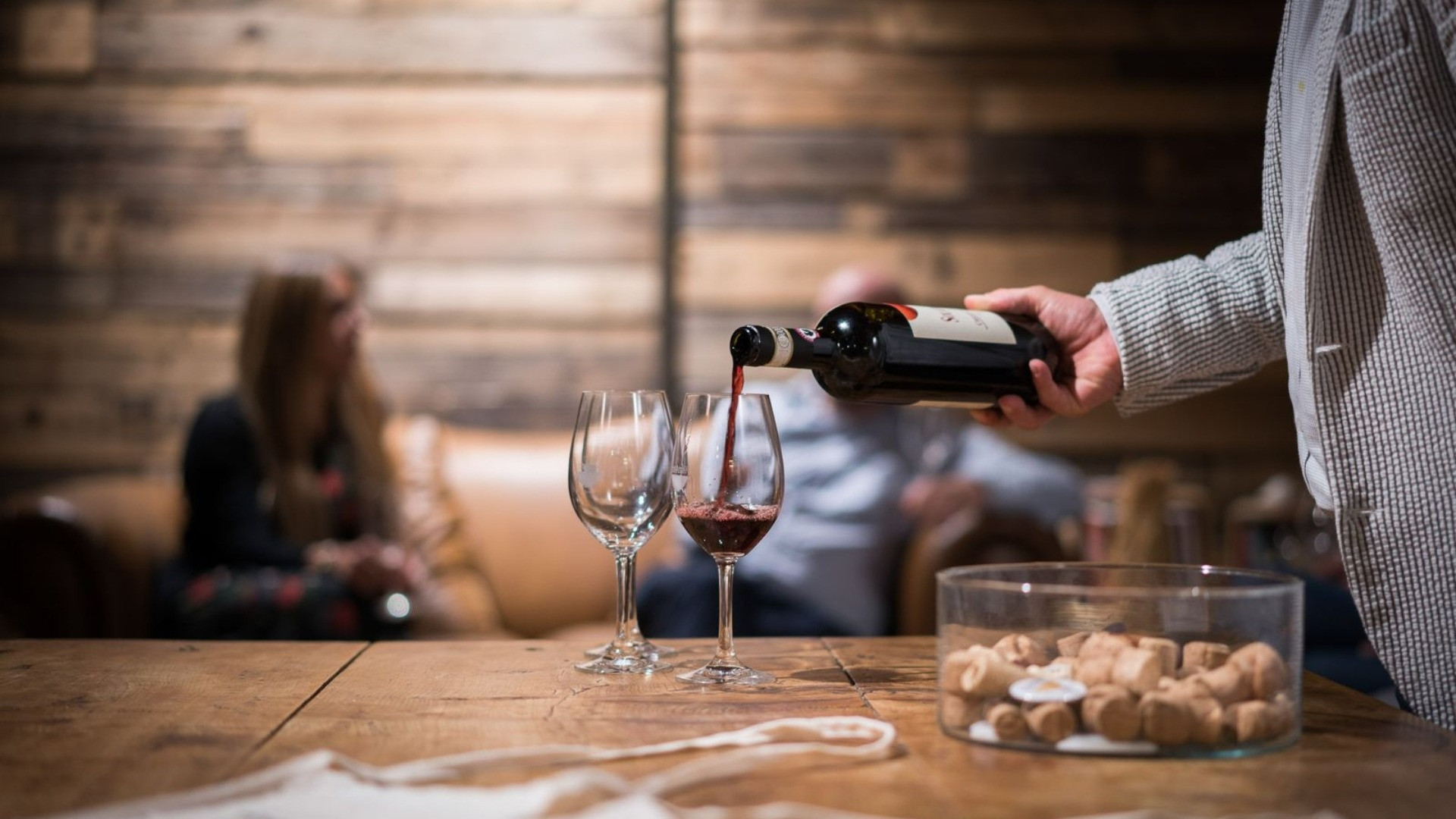 Weinexperte, der Rotwein für eine Verkostung einschenkt.